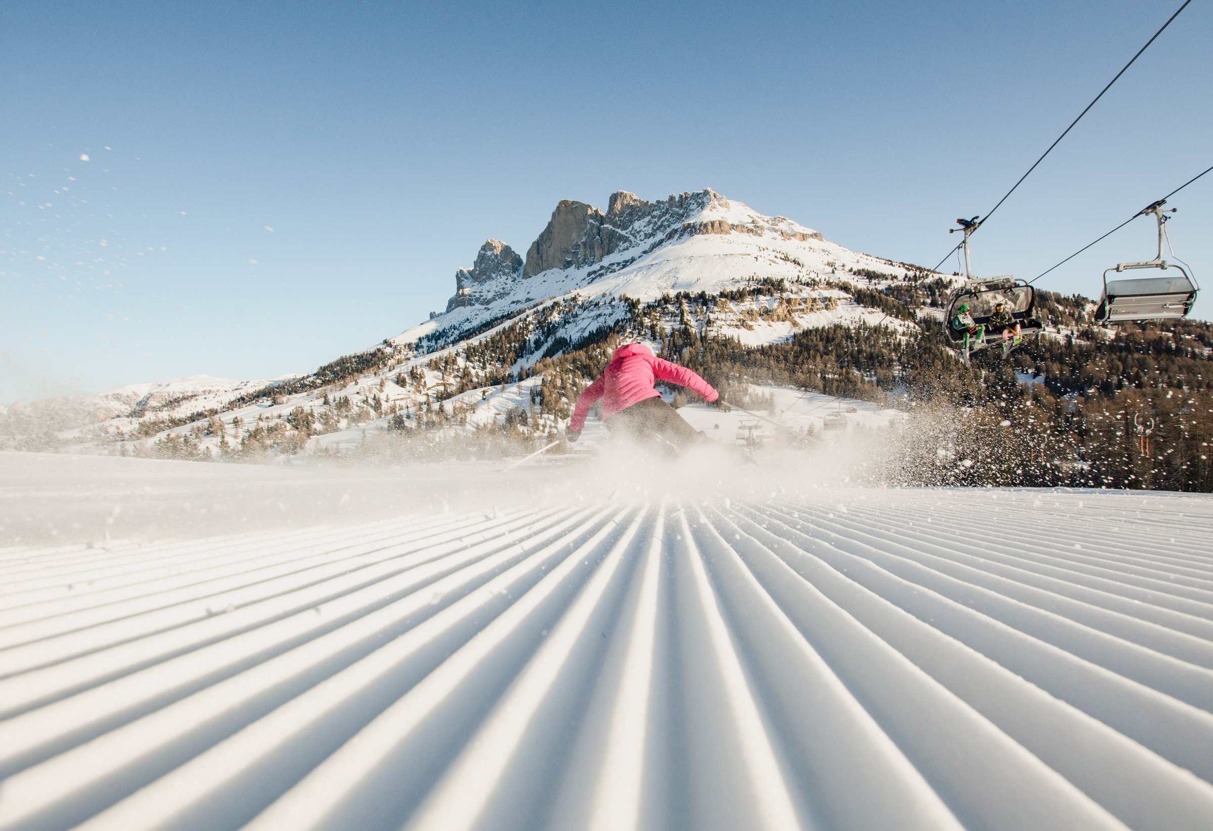 Frau fährt auf einer frisch präparierten Piste in Obereggen